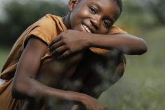 smiley-young-african-boy-standing-field-scaled